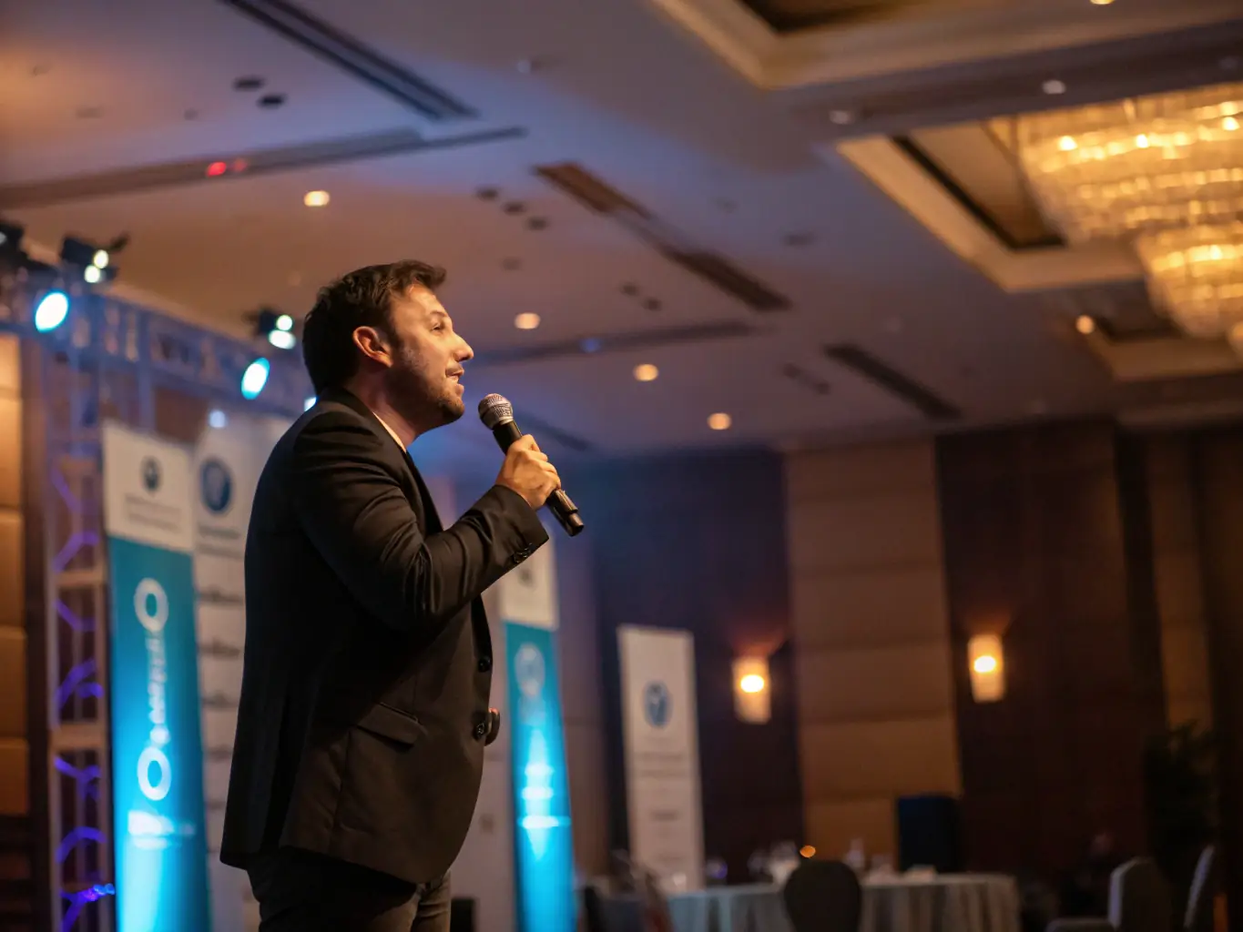 A dynamic photograph capturing a keynote speaker passionately addressing a large audience at a startup conference in Mumbai, India. The stage is brightly lit, and the audience is fully engaged.